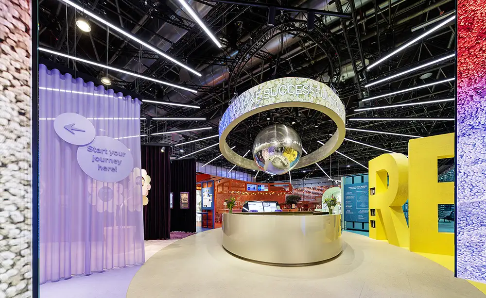 EuroShop 2026 central information and arrival zone inside the Colours of Retail exhibition concept with circular LED installation.