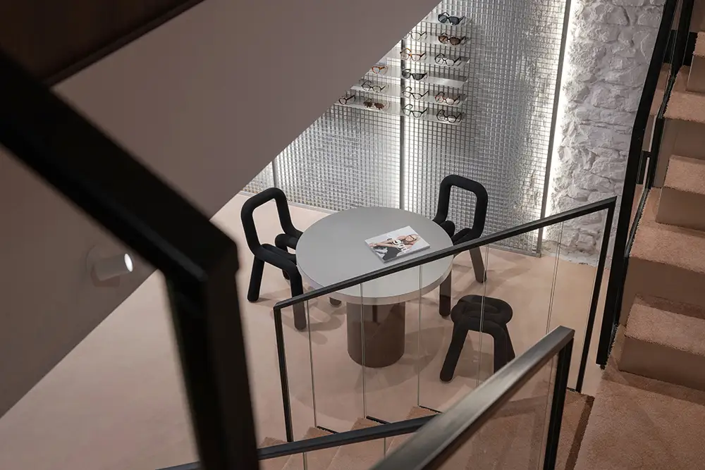 Consultation table beneath staircase at LOULOU Opticiens Lyon