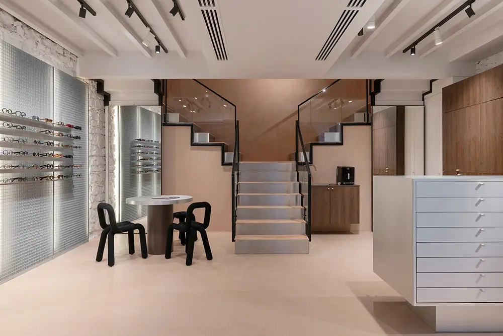 Central staircase and eyewear display inside LOULOU Opticiens Lyon