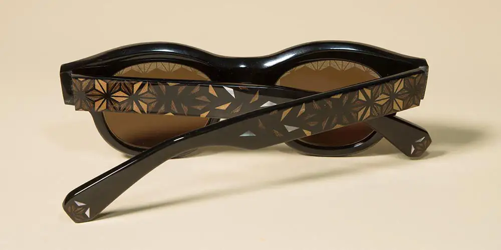 Rear view of a handcrafted spectacle frame showcasing wood inlay in eyewear design across the temples.